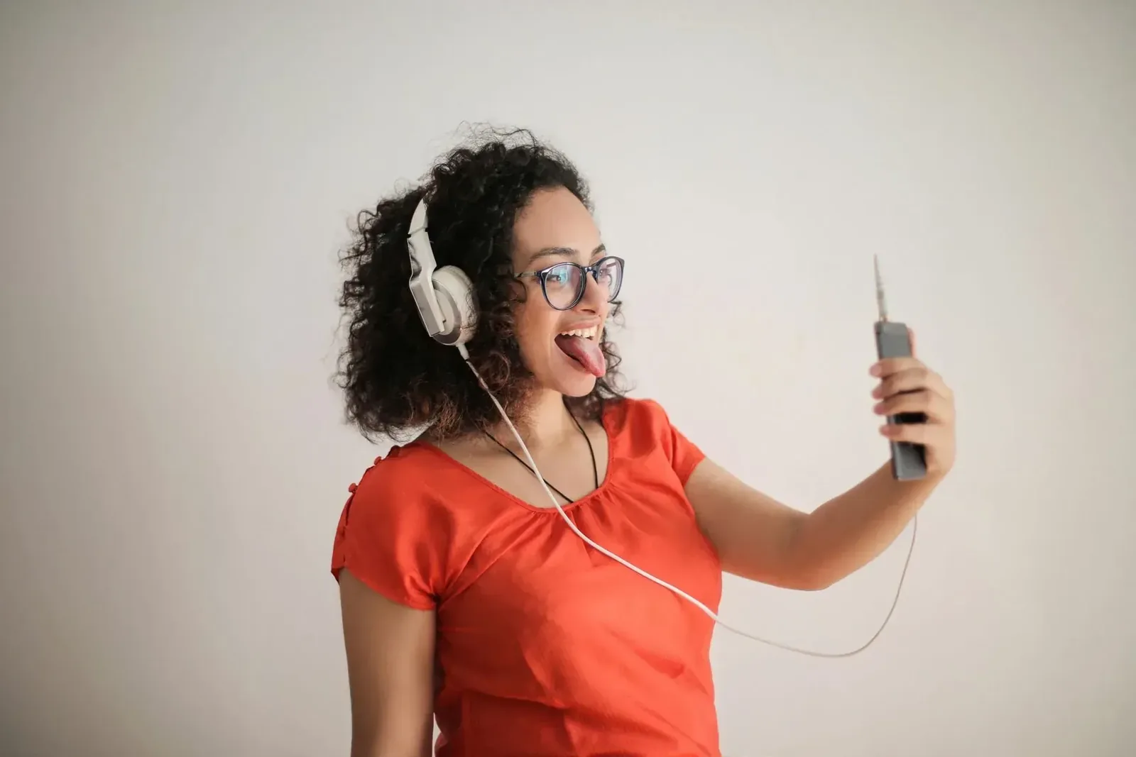 Young woman with headphones taking a selfie on her smartphone